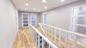 A modern interior with a wooden floor, white railing, and recessed ceiling lights. - Popock Tsaghkadzor (Tsaghkadzor)