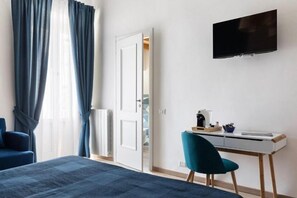 Una habitación de hotel moderna con una cama, un escritorio, una silla y un televisor montado en la pared.