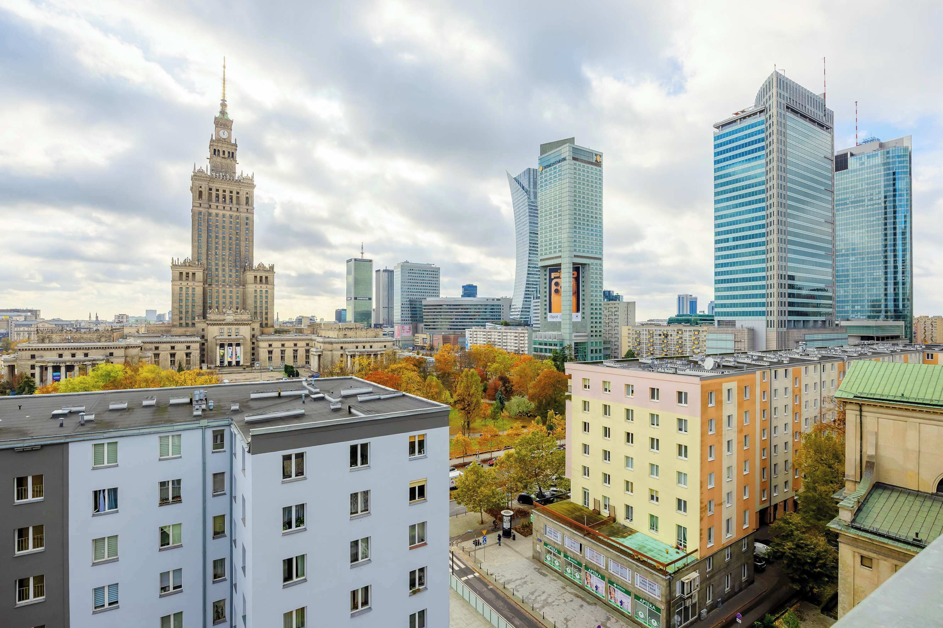 A cityscape with a historic building, modern skyscrapers, and residential buildings.