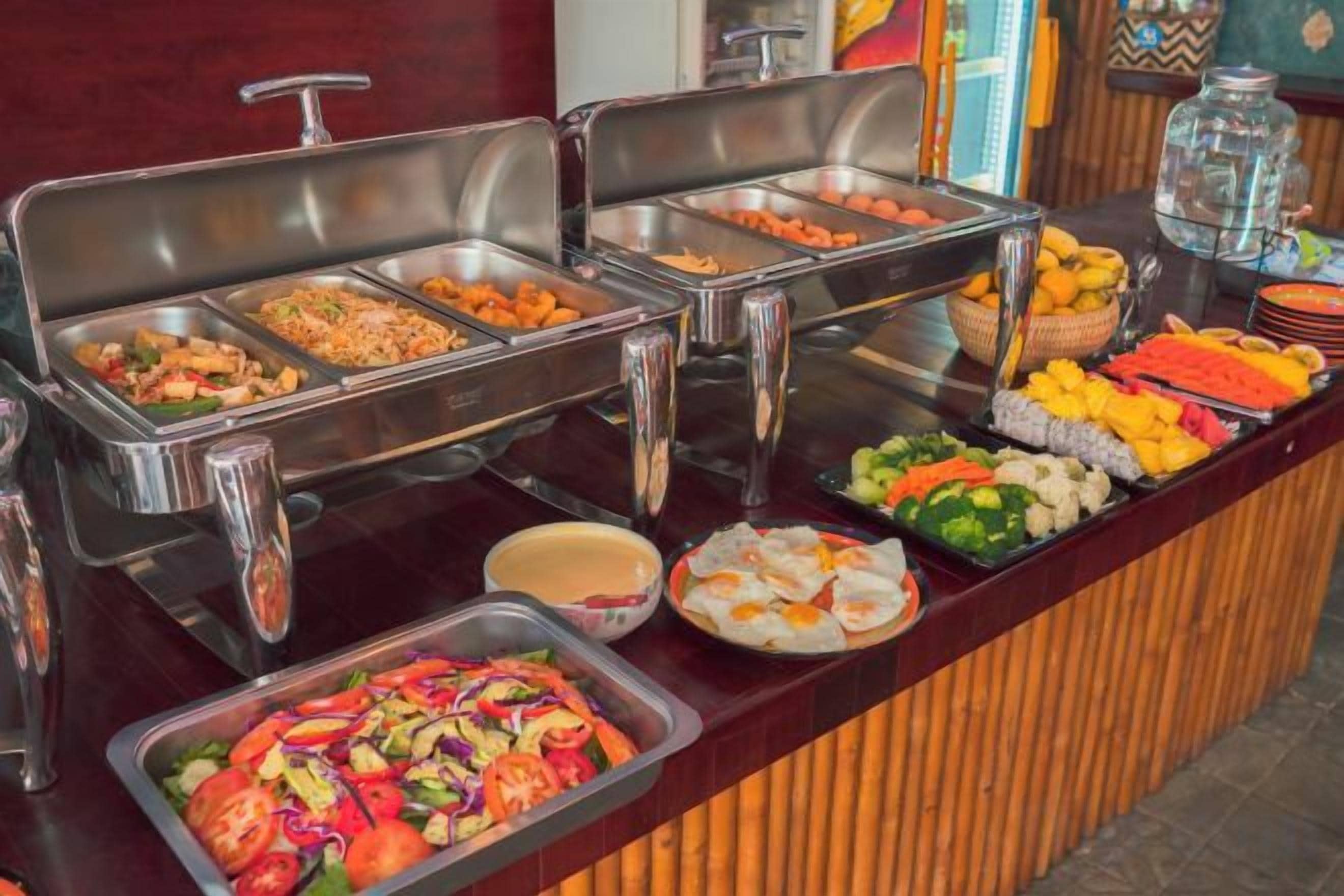 A buffet with various food items and a glass container.