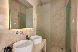 A bathroom with two white sinks, a large mirror, and a green door. - Aloft Suites Mykonos Island (Mykonos)
