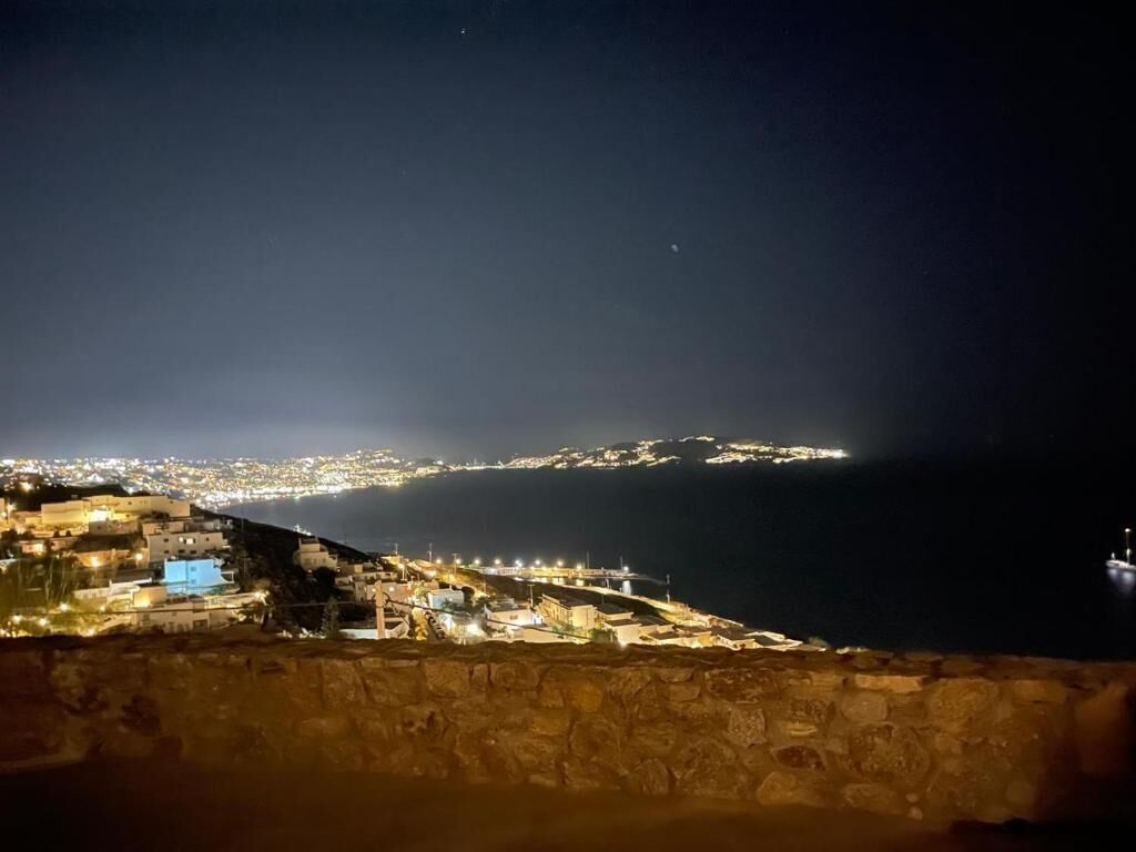 Un pueblo costero iluminado de noche, con vista al mar.