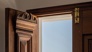Una puerta de madera con vistas a un paisaje costero a través de una ventana abierta.