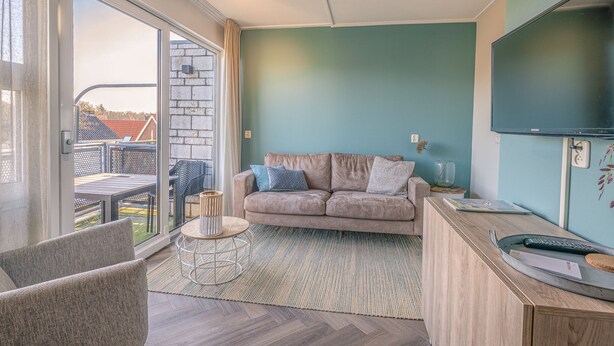 A modern living room with a sofa, a coffee table, and a TV. - Tasteful 2-person Apartment Near the Center of De Koog (De Koog)