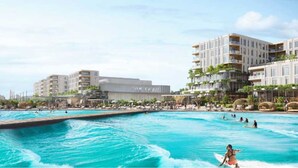 Resort com piscina grande, vários edifícios e céu claro.
