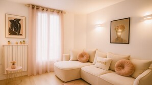 En moderne stue med en beige sofa, et lille sofabord og en radiator.