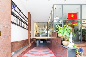 L’entrée d’un hôtel, avec un tapis rouge, un drapeau et une statue.