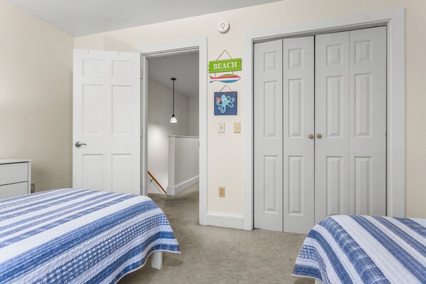 A bedroom with two beds, a closet, and a hallway leading to another room. - Quiet corner in the heart of Bar Harbor. A few openings still left. Reserve now! (Bar Harbor)