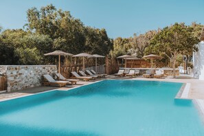 Una piscina al aire libre de temporada, sombrillas