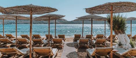 Plage, sable blanc, chaises longues, parasols