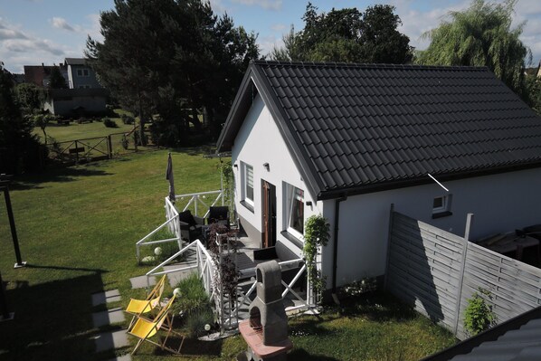 A house with a sloped roof, a fenced yard, and a small porch area. - New Holiday Home for 5 People in Wiselka (gmina Wolin)