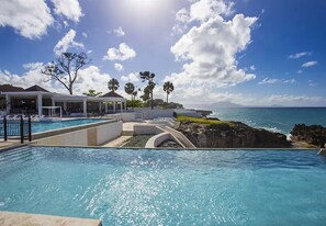A pool area with a view of the ocean and a covered seating area. - Bubble Glamping King Bed, we Have a 8 Units Like This! (Sosúa)