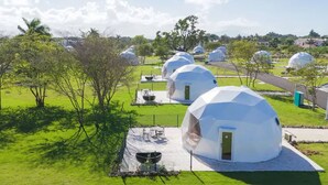 A series of geodesic dome structures with outdoor seating areas and a grill. - Bubble Glamping King Bed, we Have a 8 Units Like This! (Sosúa)