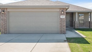 A single-story house with a garage door, brick exterior, and a visible address number. - Beautiful brand new home. Just entered VRBO market November 6.  All things new! (Lubbock)