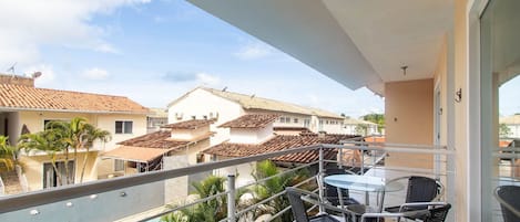 A balcony with a pool, chairs, and a table.