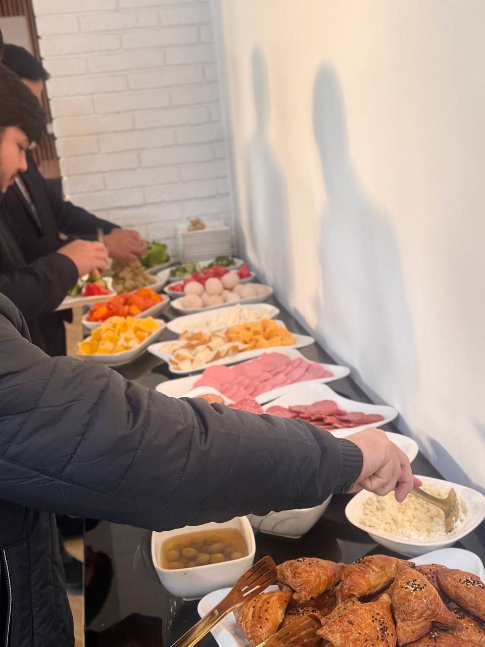 Un bufé con una variedad de alimentos, como frutas, verduras, carnes y pasteles.