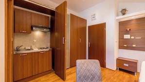 A compact room with a kitchenette, a bed, a chair, and a wardrobe. - Stay @ Bolotel studio SAVE 20 percent on Zlatnirat-bol com (Bol)