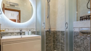 A modern bathroom with a glass-enclosed shower, a round mirror, a white sink, and a toilet. - Stay @ Bolotel studio SAVE 20 percent on Zlatnirat-bol com (Bol)