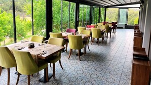 Un restaurant doté d’une terrasse, de grandes fenêtres et de carreaux de sol décorés.
