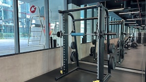 Ein Fitnessstudio mit Gewichte, großen Fenstern und einem Betonboden.