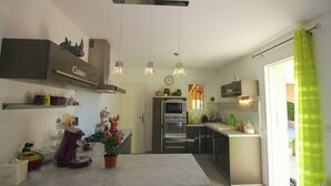 Una cocina moderna con una isla central, electrodomésticos integrados y un diseño luminoso y espacioso.