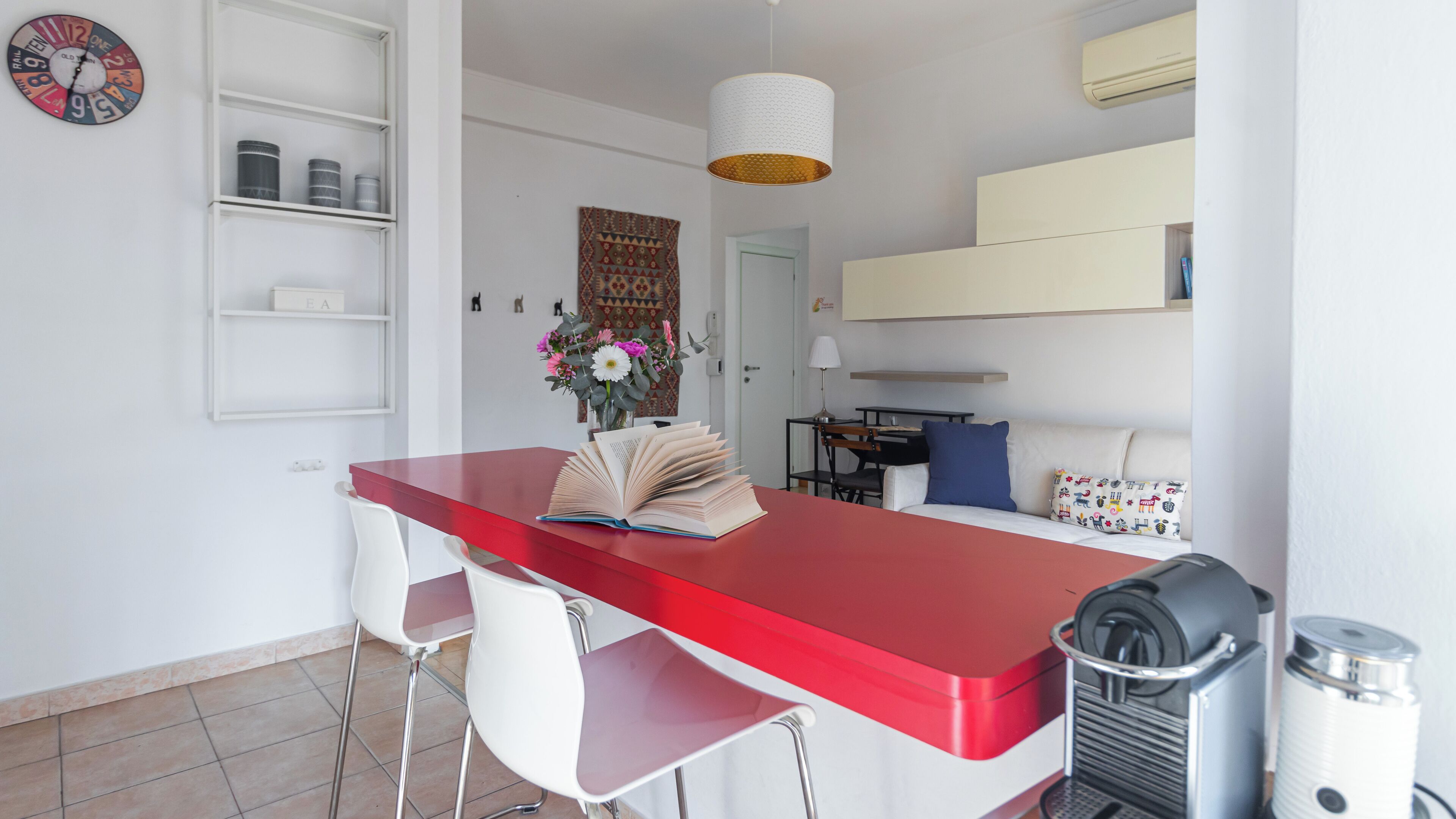 A compact living space with a kitchenette, a dining area, and a bed.
