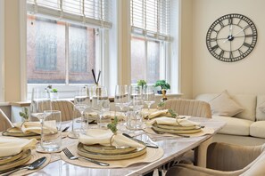 A dining table set for a meal with clear glassware, plates, and cutlery. - Tottenham Court's Road - 2Bed Apartment (London)