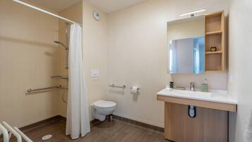 A modern bathroom with a shower, toilet, and sink.