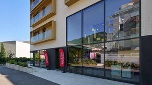 A modern building with large glass windows and a flat facade. - Quality Aparthotel Voiron (Voiron)
