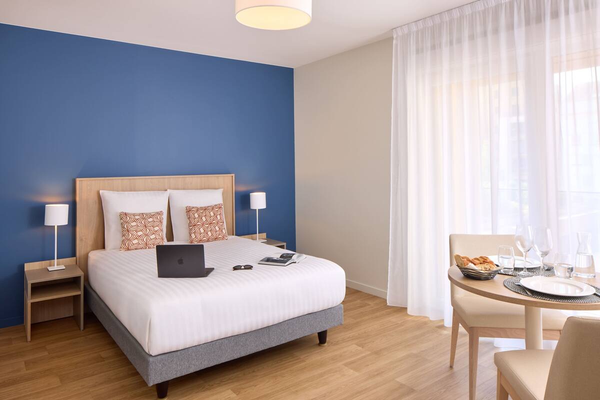 Ein Hotelzimmer mit Bett, Schreibtisch und Essbereich.