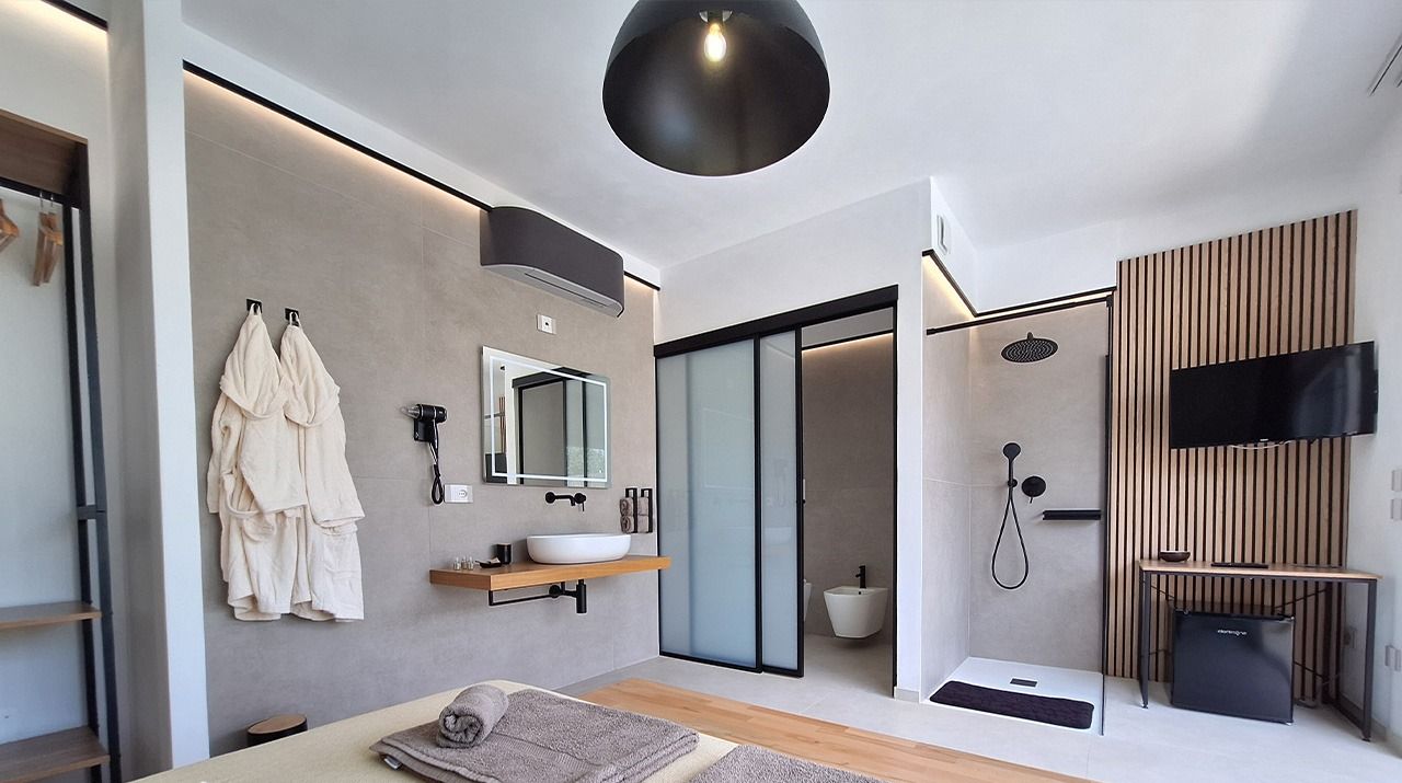 Un moderno cuarto de spa con una cama grande, un lavamanos, un espejo y una zona de ducha.