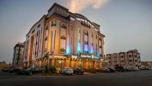 A hotel with a prominent sign, multiple balconies, and a parking lot. - Golden Rose Hotel (Jizan)