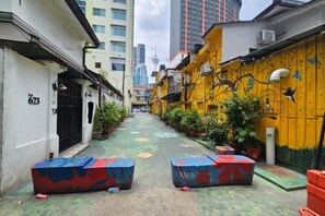 A narrow alleyway with buildings on either side, some with visible balconies and air conditioning units. - Red Velvet Inn Bukit Bintang (Kuala Lumpur)