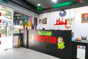 A reception desk with a clock, framed pictures, and a 'No Entry' sign. - Red Velvet Inn Bukit Bintang (Kuala Lumpur)