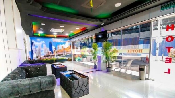 A hotel lobby with a reception desk, seating area, and a large window with the hotel name. - Red Velvet Inn Bukit Bintang (Kuala Lumpur)