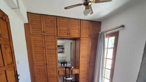 A bedroom with a bed, wooden wardrobe, a desk with a chair, and a ceiling fan. - Serene building with AC in beautiful Bodrum (Bodrum)