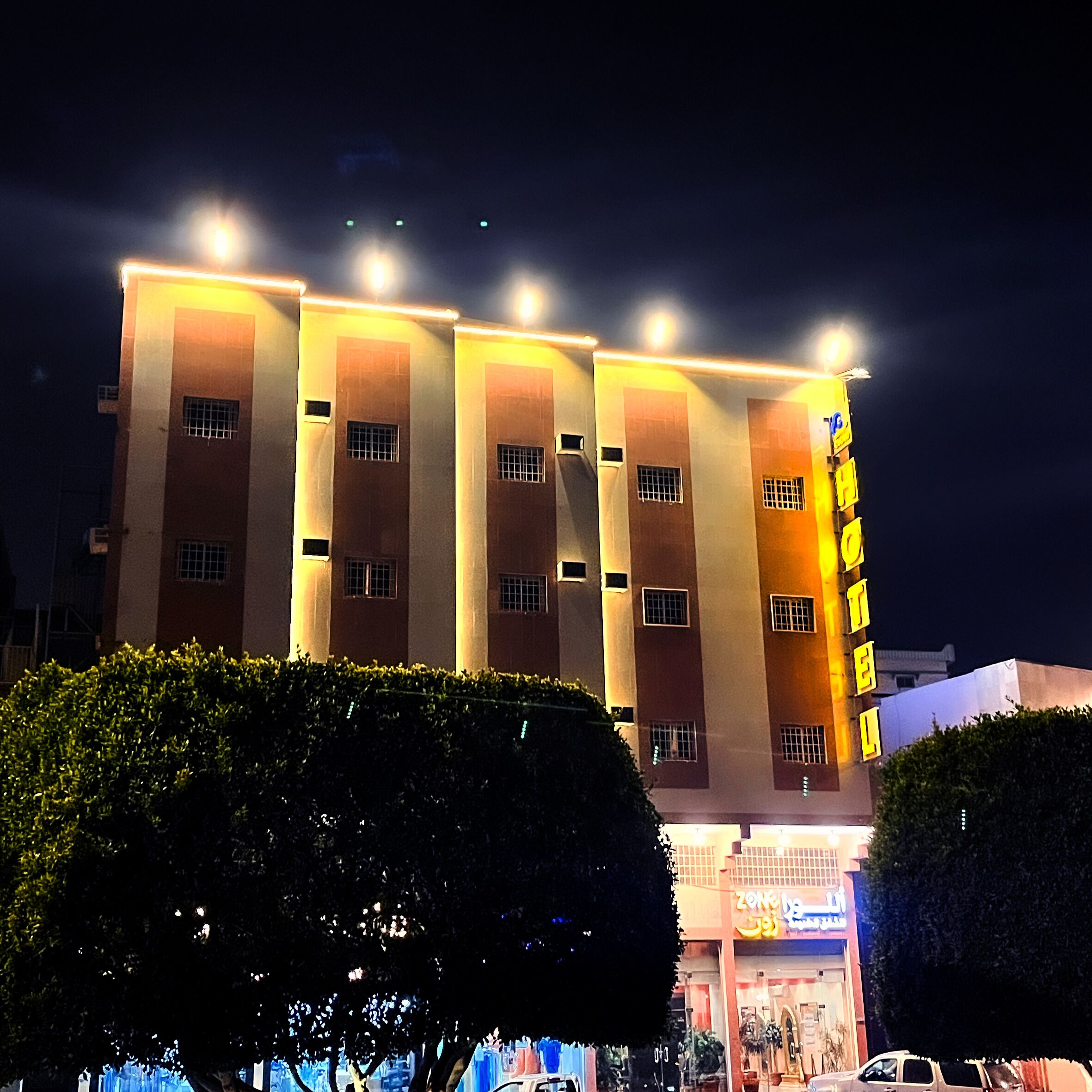 Edificio di un hotel su più piani con insegne illuminate e un ingresso ben visibile.