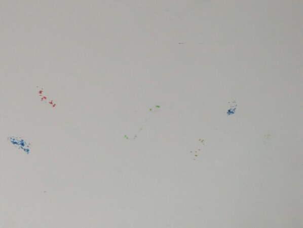 Una pared blanca y lisa con pequeños puntos de colores dispersos.