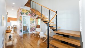 Um interior moderno com escada de madeira, área de refeições e cozinha.