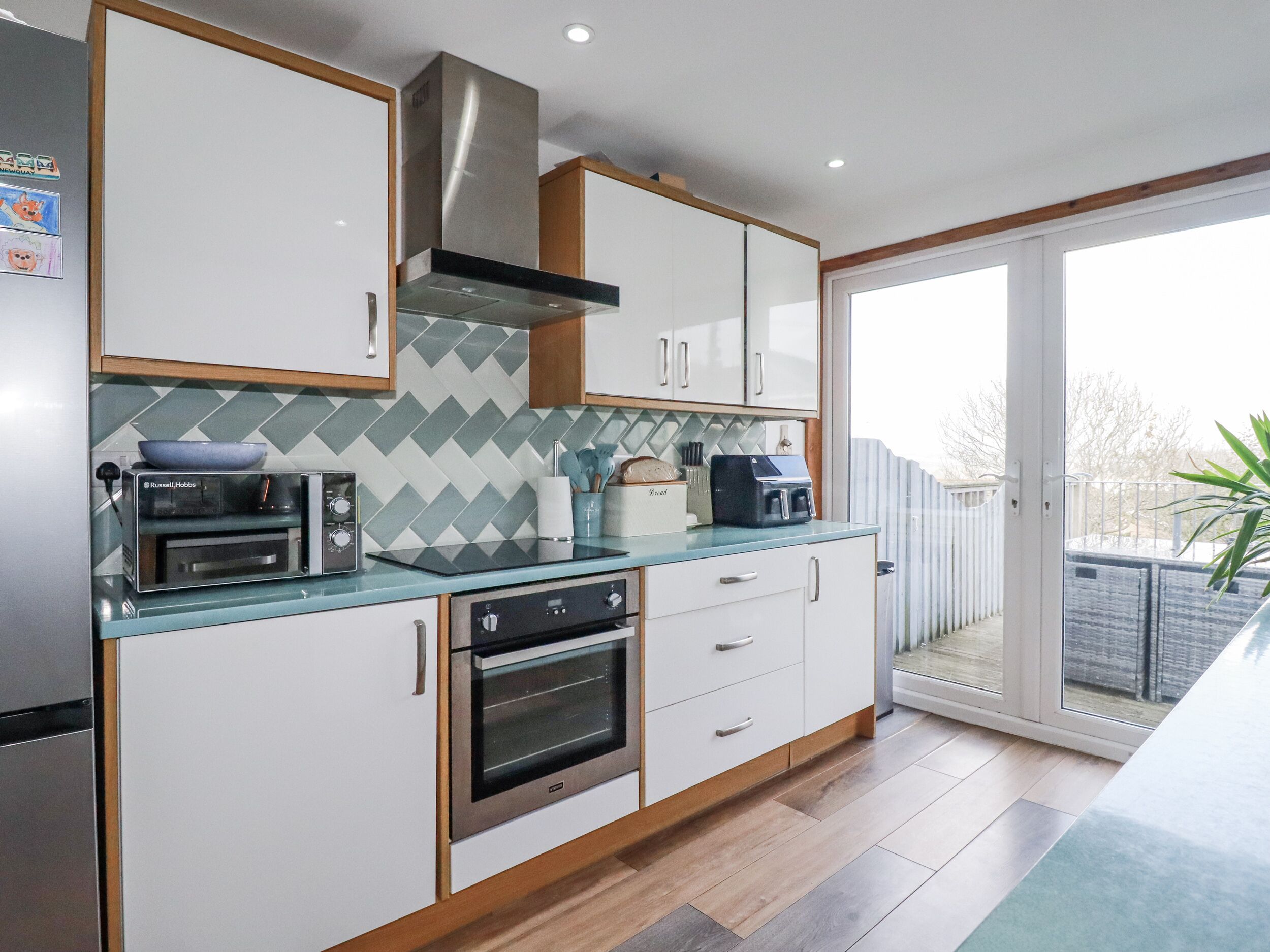 A modern kitchen with a built-in oven, a toaster, and a coffee machine.
