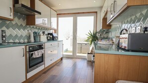 A modern kitchen with a built-in oven, a coffee machine, and a toaster. - Sea Boots (Newquay)