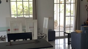 A modern kitchen with a marble countertop, white cabinetry, and a dining area with a table and chairs. - Villa Tropical Deluxe No. 10, near the beach, Cabarete (Cabarete)