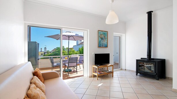 Una sala de estar con sofá, televisión y chimenea.