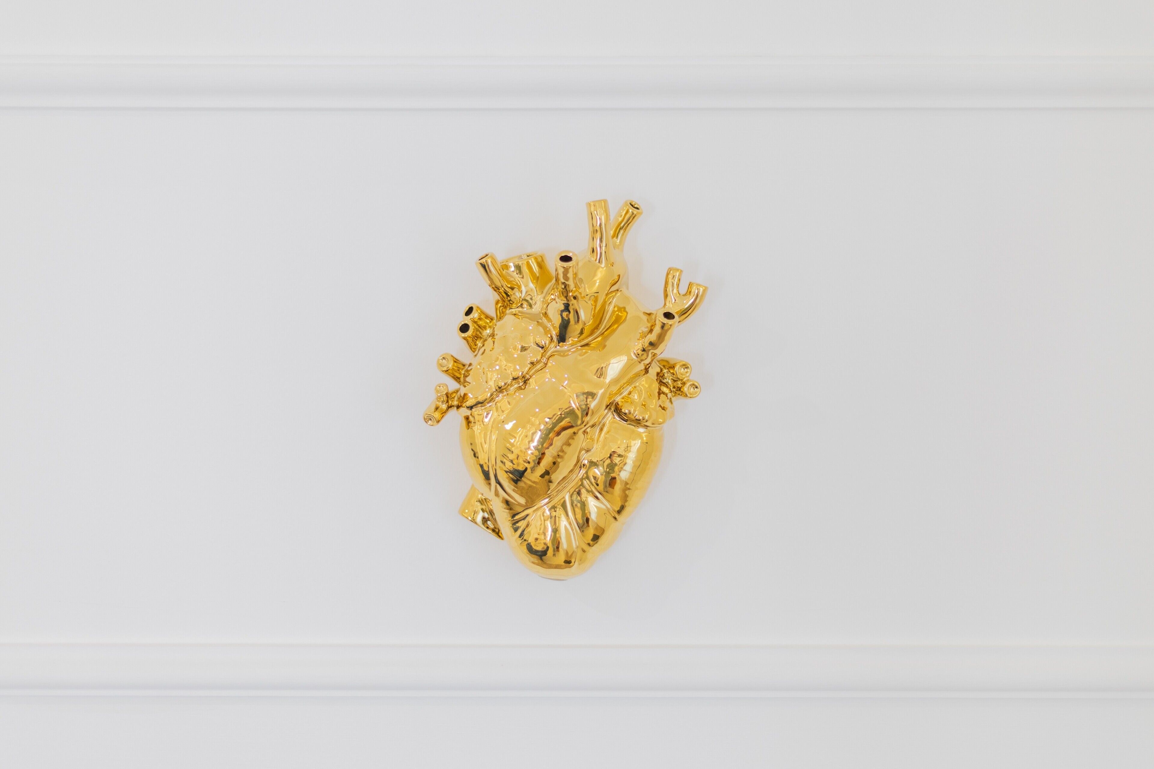A gold heart-shaped object on a white surface.