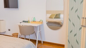 A bedroom with a bed, a desk, a chair, a television, and a mirror. - Villa Vetrano – Spacious Apartment in Nola (Cimitile)