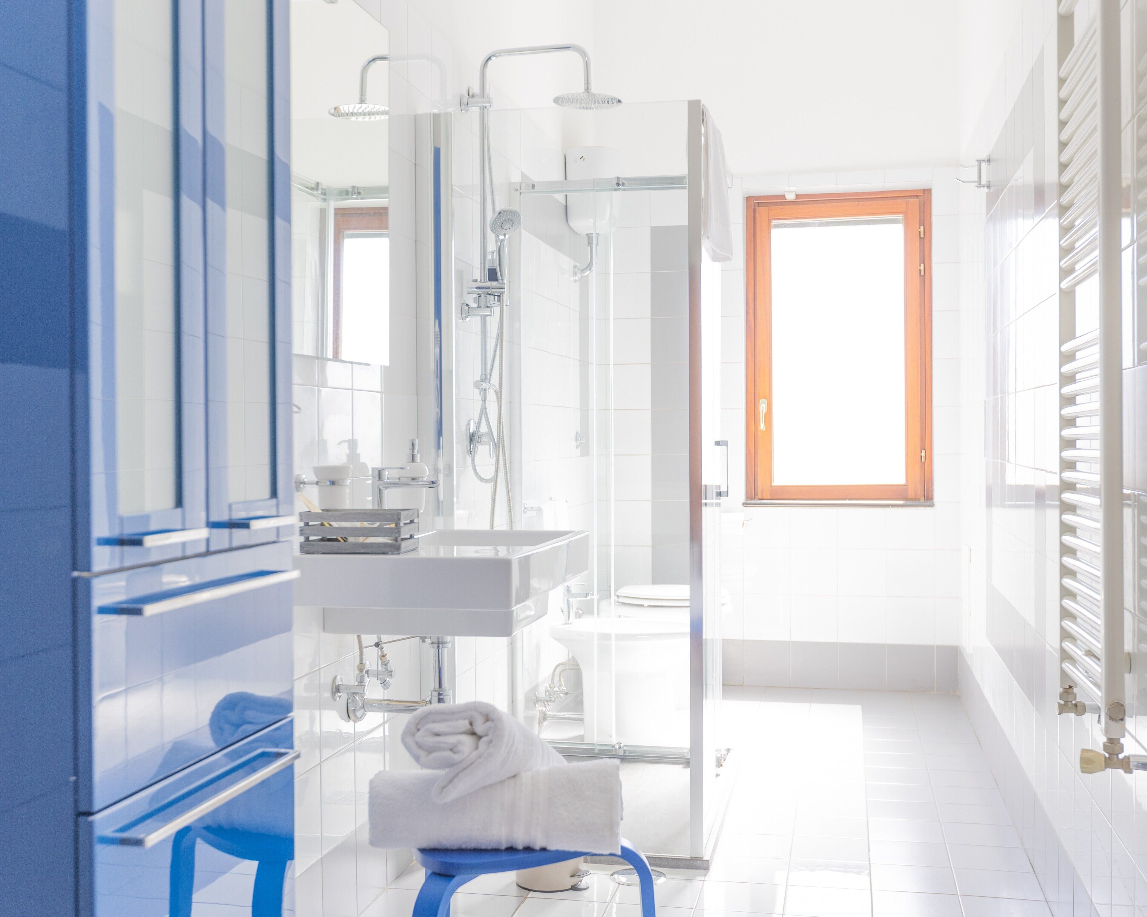 A modern bathroom with a shower, sink, and toilet.