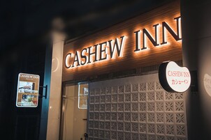The exterior of the Cashew Inn with illuminated signage and a decorative facade.