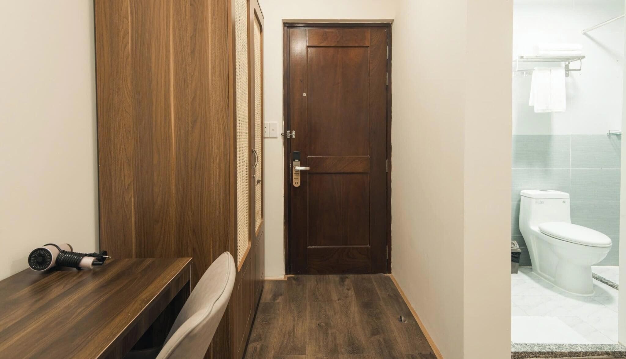 A bathroom with a wooden vanity, a white toilet, and a shower area.