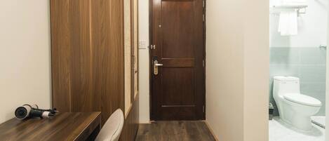 A bathroom with a wooden vanity, a white toilet, and a shower area.