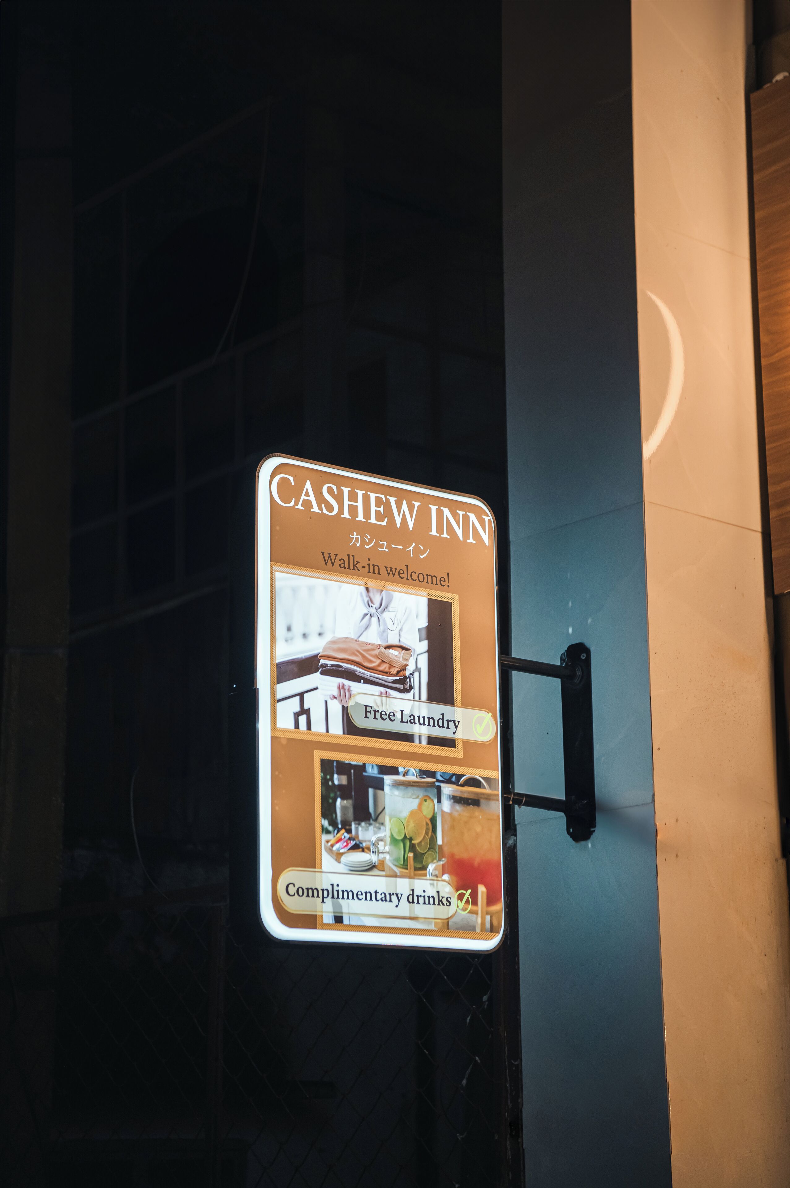 A sign for the Cashew Inn with amenities like free laundry and complimentary drinks.